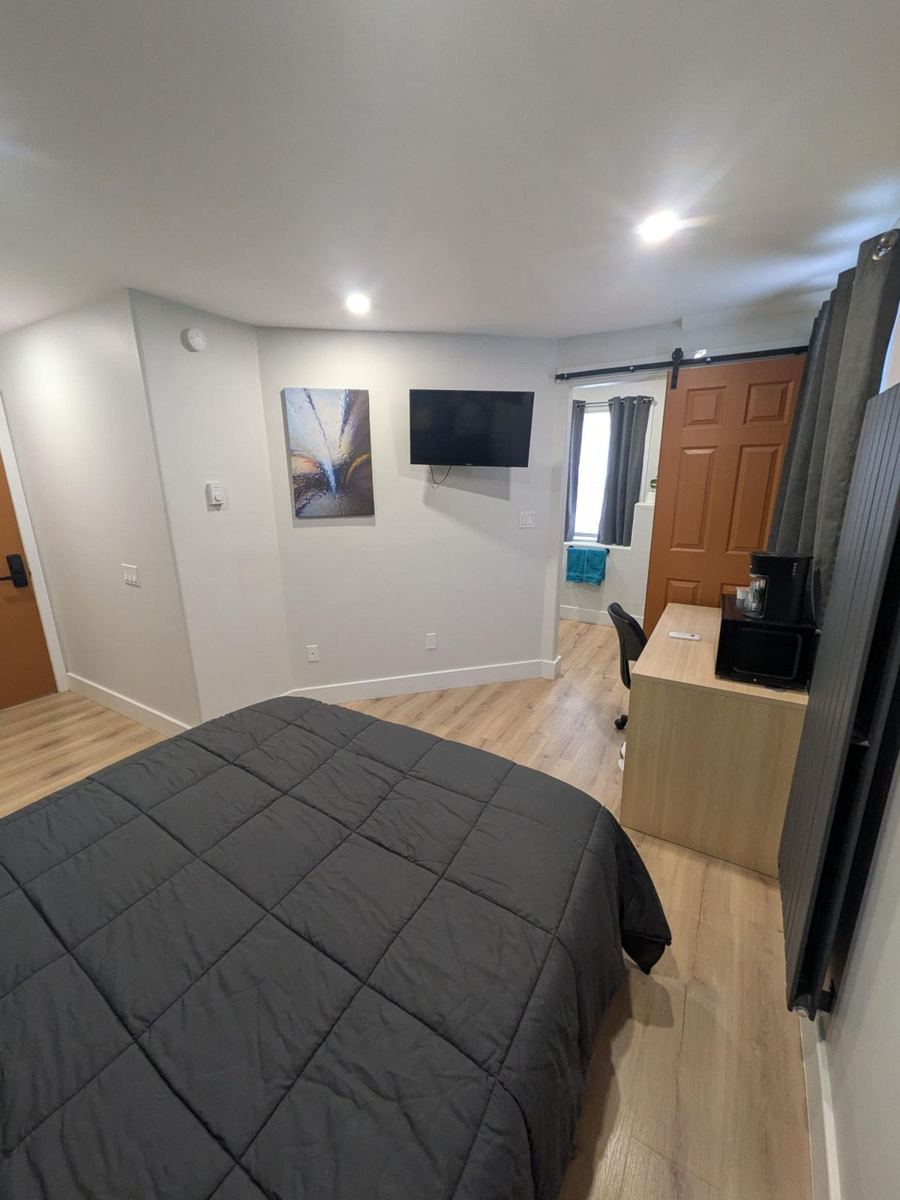 Queen bed, desk and barn door to the bathroom